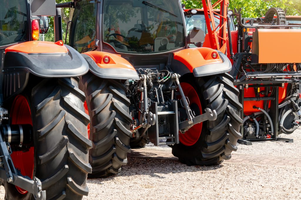 rear view of orange tractors on display outdoors at a farmland dealership
