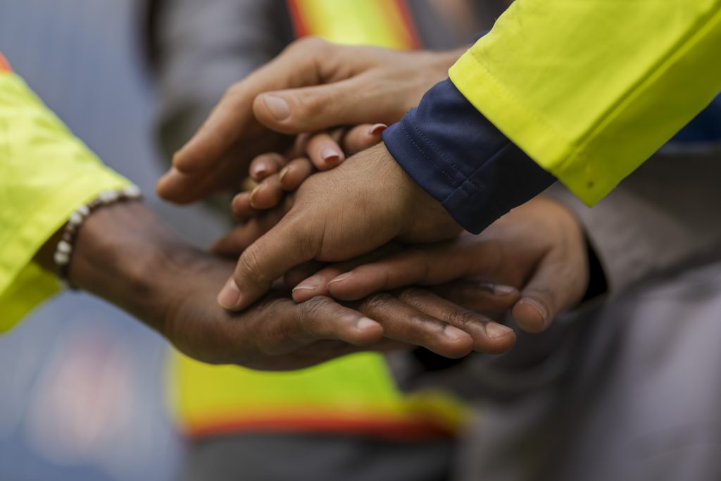 workers in high visibility safety gear and hard hats discuss ope