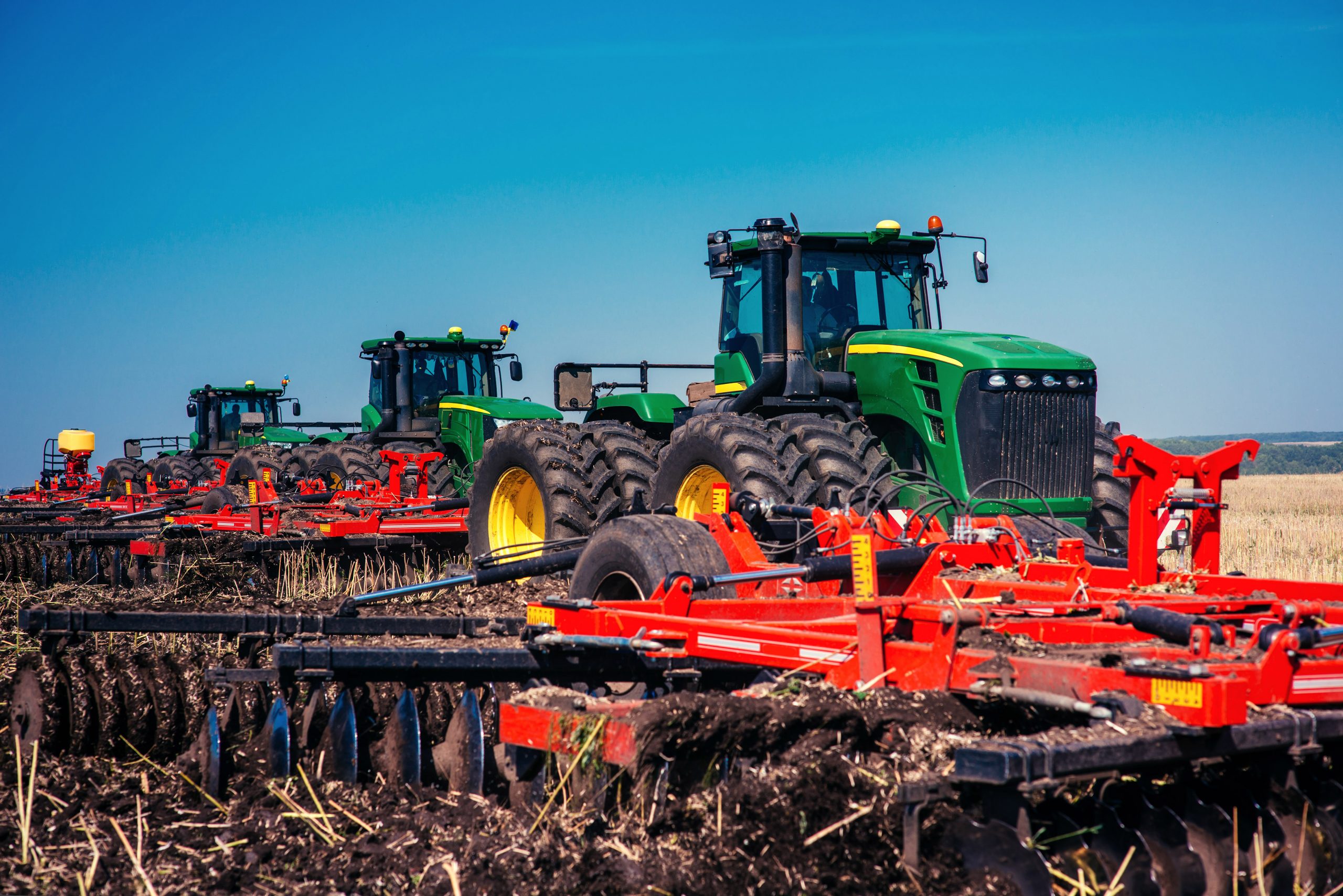 tractor plowing farm field in preparation for spring planting