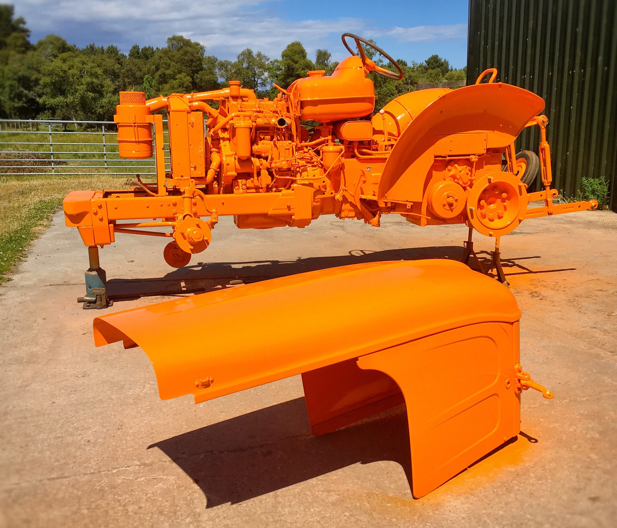 freshly painted orange tractor outdoors on concret 2026 03 16 02 10 25 utc