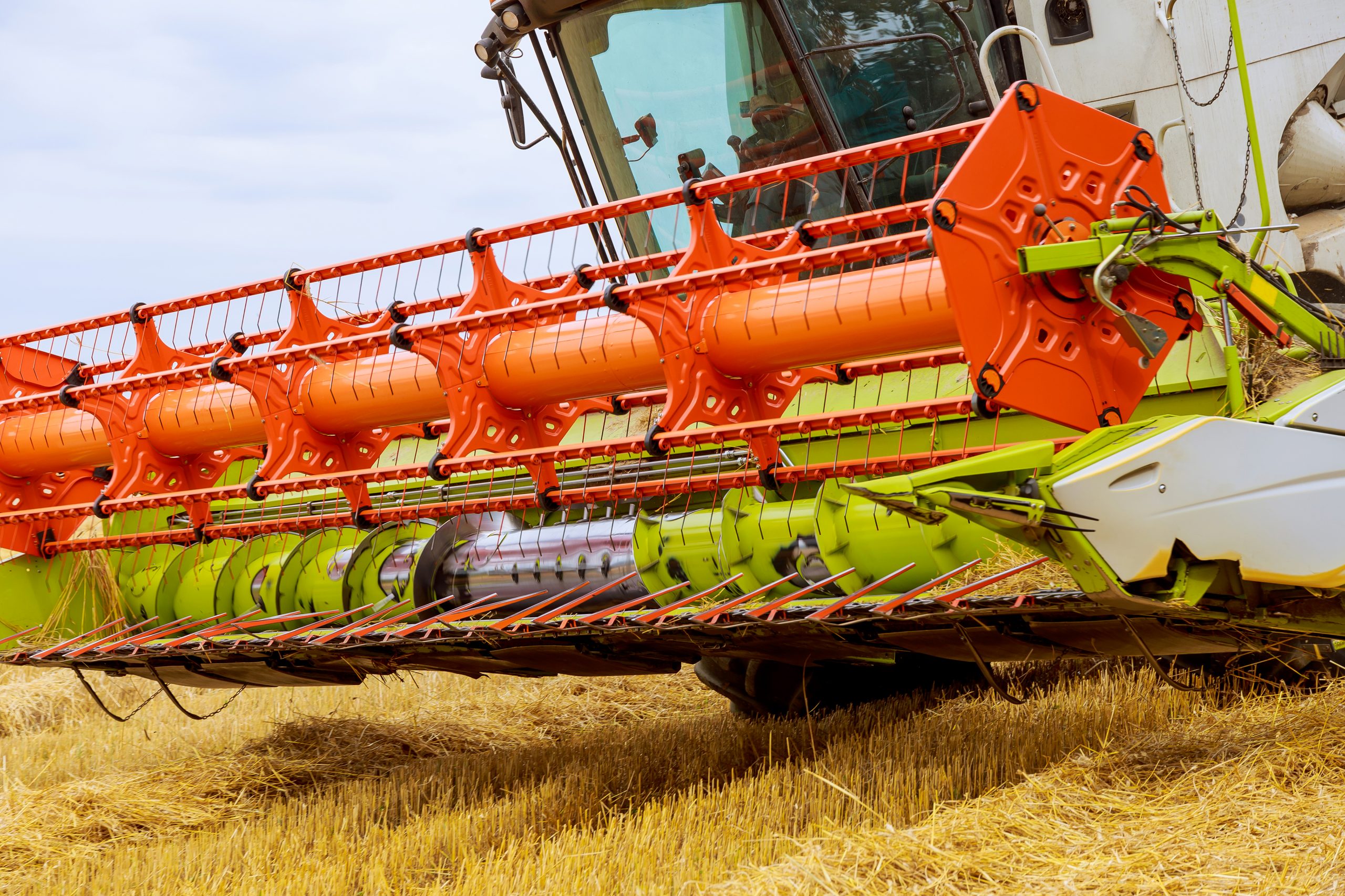 the combine stands on stubble in the field after harvest.